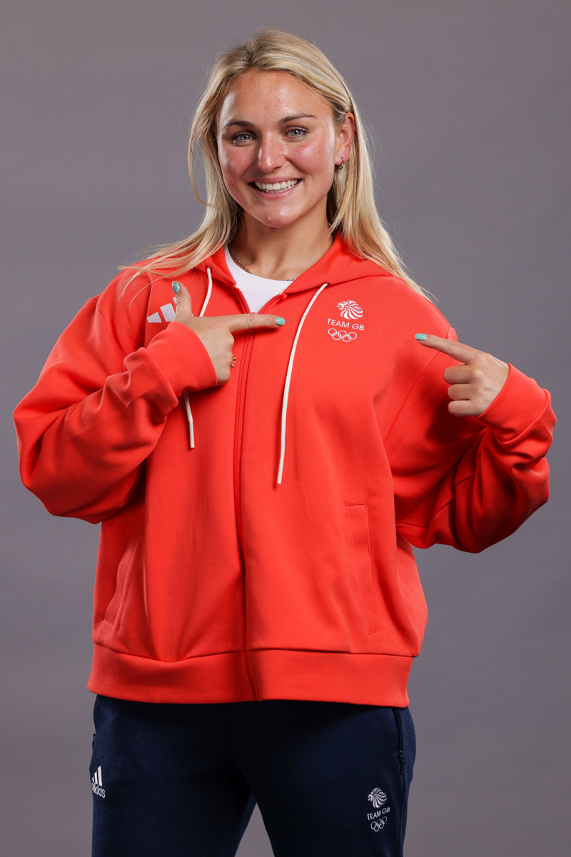Coach is posing for a photo in her team's dress.